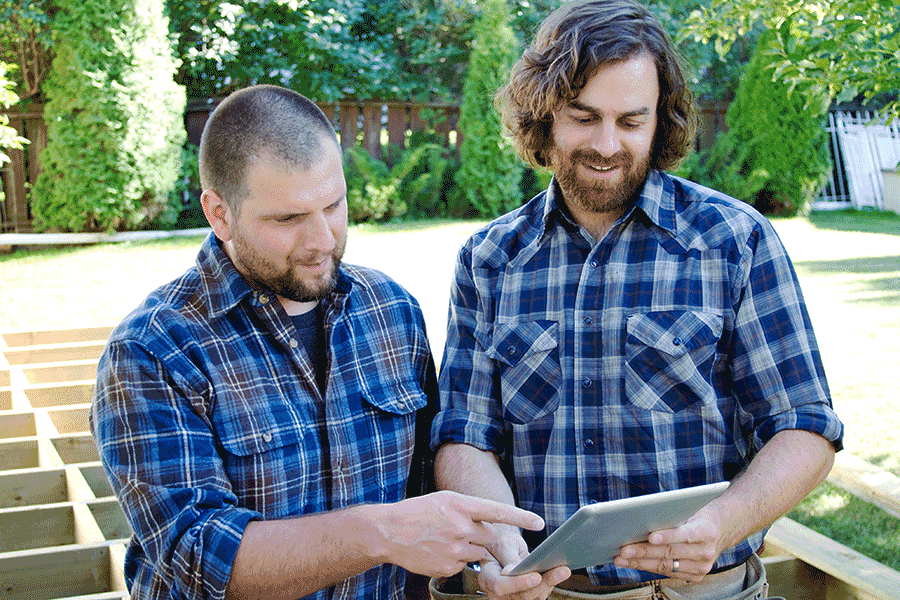 Two carpenters planning on tablet