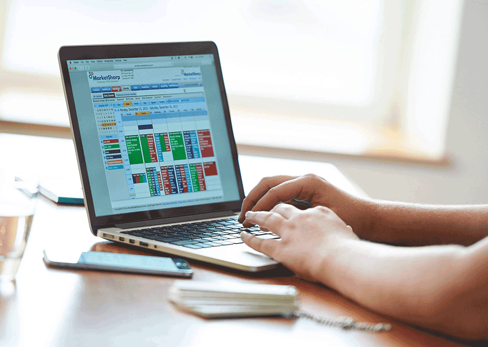 Salesperson on laptop using MarketSharp calendar
