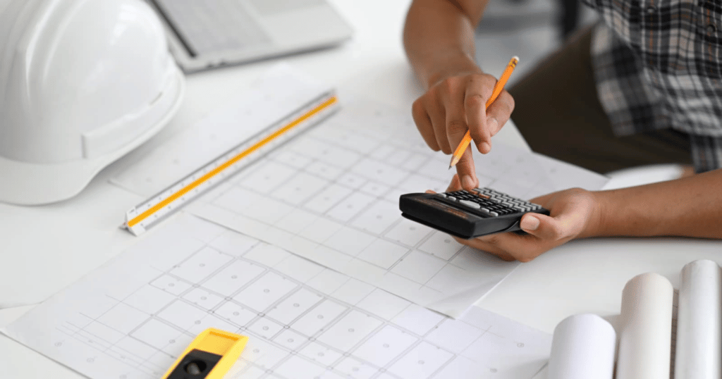 image of someone using a calculator to calculate their material costs to price jobs accurately.