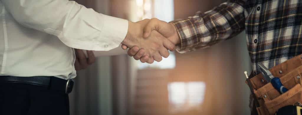 remodeling worker and contractor shaking hands with client 