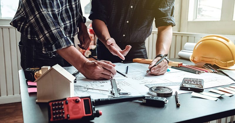 two people looking at a blueprint for remodeling