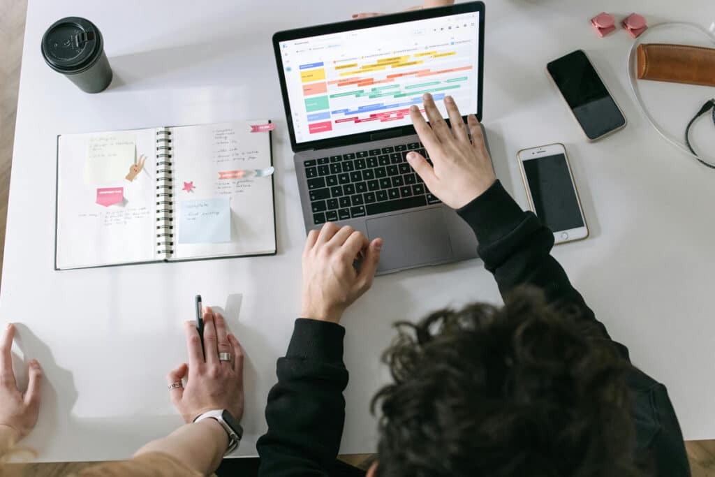 Team reviewing job schedules on a laptop while using field service management software for planning.