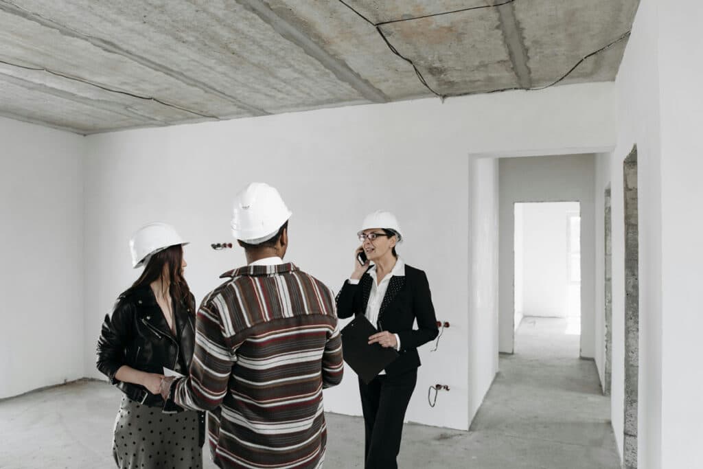 Licensed home improvement contractors discussing renovation details with a client during a site walkthrough.