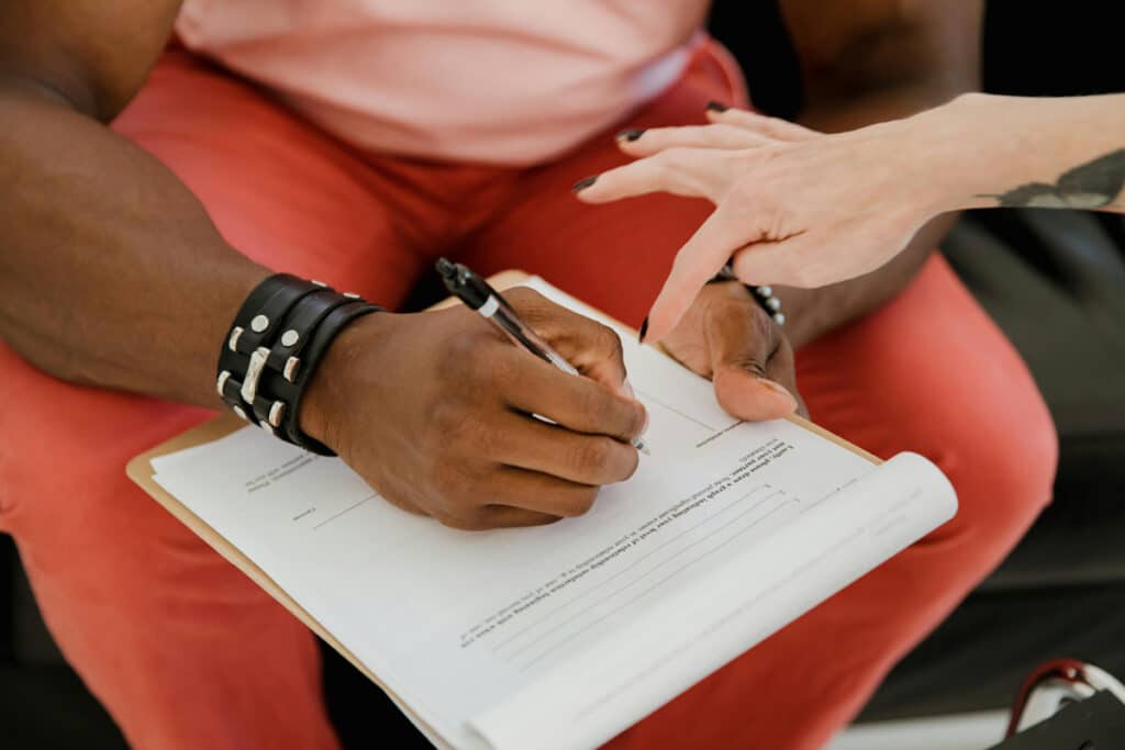Contractor completing paperwork and signing forms for a home improvement contractor license application.