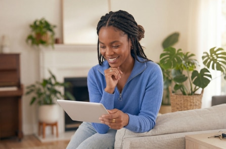 A homeowner checks company reviews on her tablet and smiles.